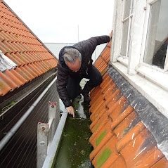 Fred Tokkie inspecteert een dakgoot