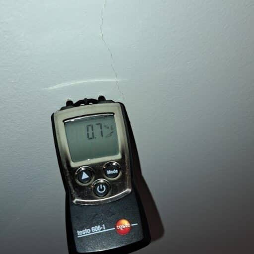 Close-up of a moisture meter display during a damp survey in Amsterdam