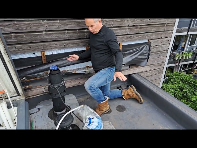 Inspector on a flat roof terrace next to a vent pipe